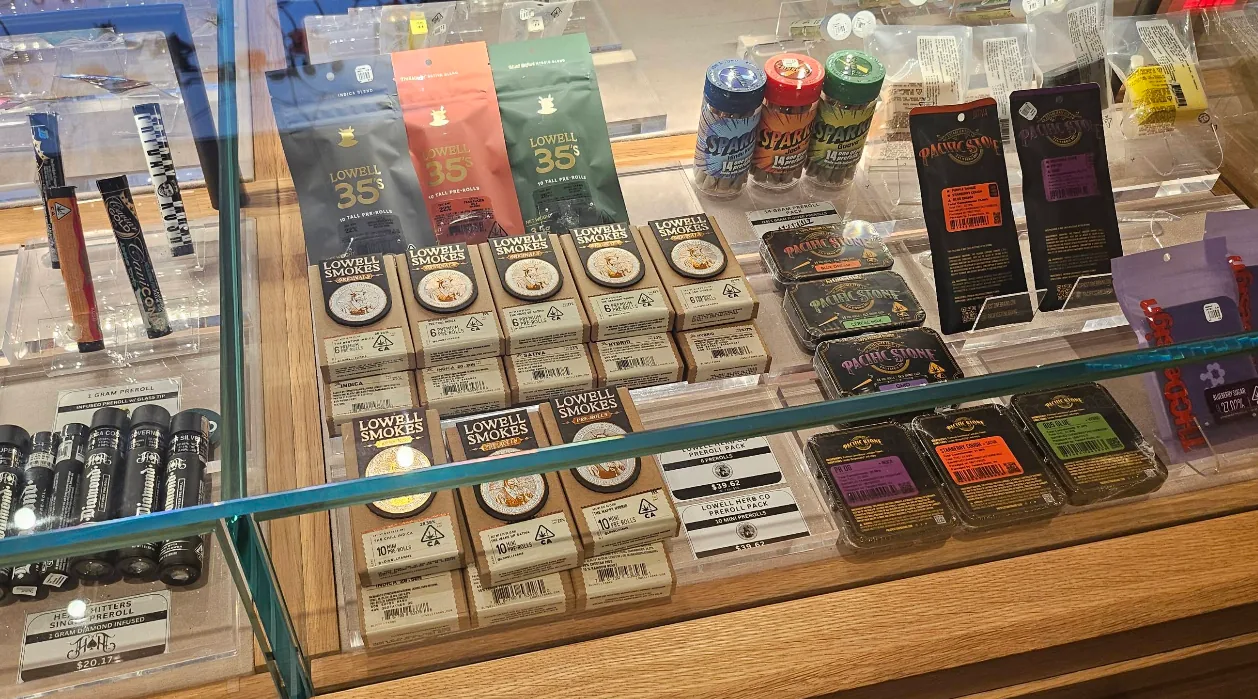Home 16 The pre-roll case at Caña Beverly, packs and tins laid out under glass