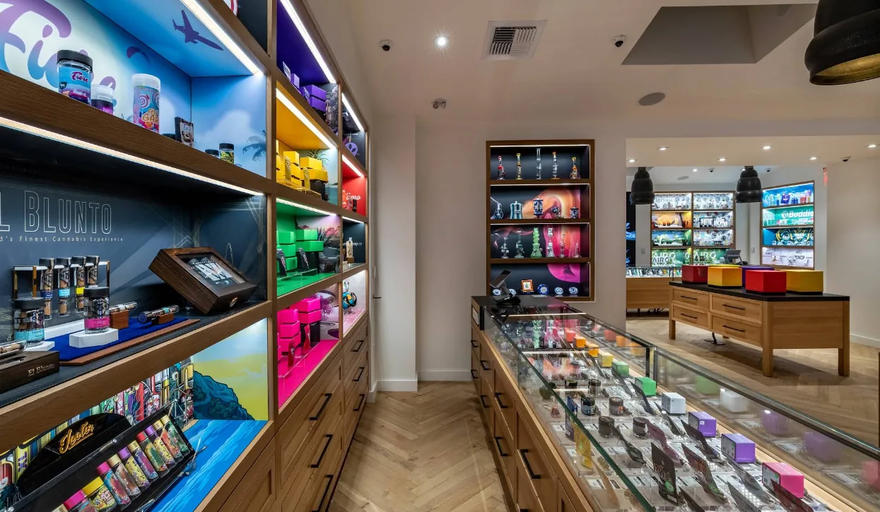 Home 14 The glass case aisle at Caña Beverly, lit shelves on both sides of a herringbone floor